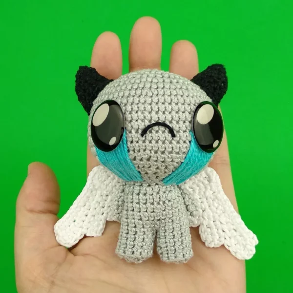 Binding of Isaac Apollyon Crochet Amigurumi on holding hand over green background