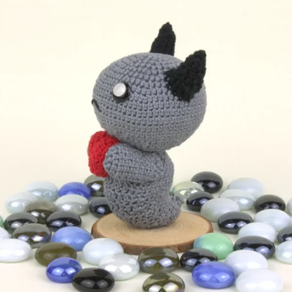 Binding of Isaac Dark Bum Crochet Amigurumi side view next to pearl stones