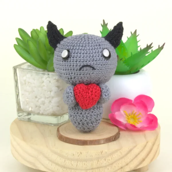 Binding of Isaac Dark Bum Crochet Amigurumi next to plants and flowers