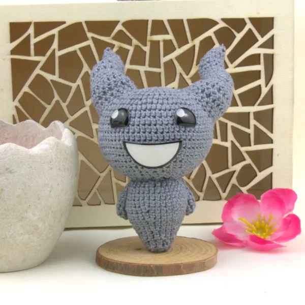 Binding of Isaac Lil Brimstone Crochet Amigurumi next to flowers