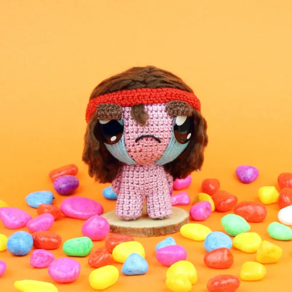 Binding of Isaac Samson Crochet Amigurumi next to colorful stones over orange background