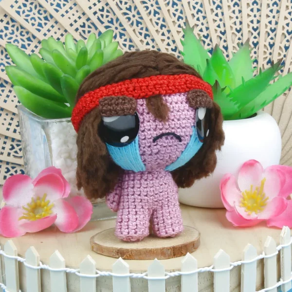 Binding of Isaac Samson Crochet Amigurumi next to decorative plants and flowers