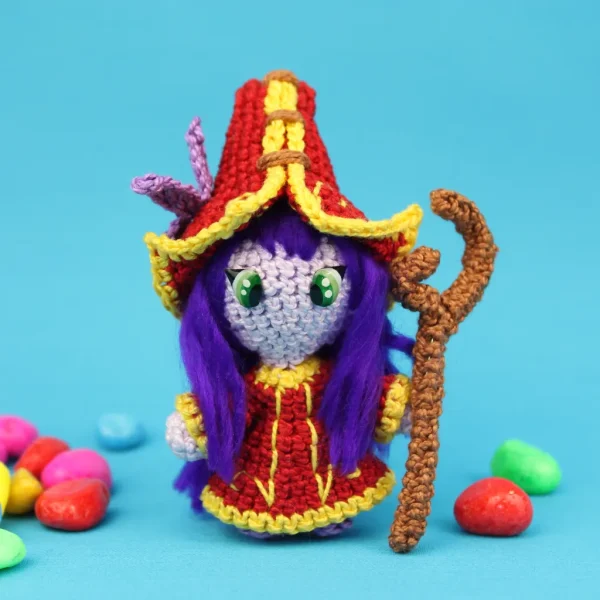 League of Legends Lulu Crochet Amigurumi nextg to coloured stones over blue background