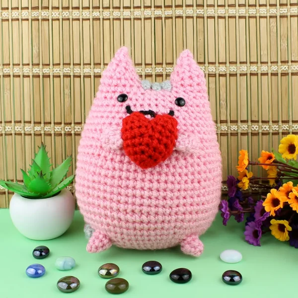 Pink Pusheen Kawaii Cat XL Crochet Amigurumi next to pearl stones and decorative plant