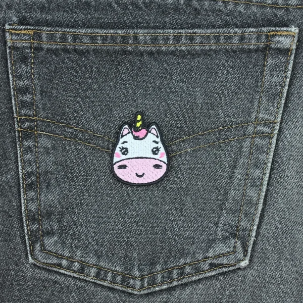 Small White and Pink Kawaii Unicorn Embroidered Patch on Black Jeans