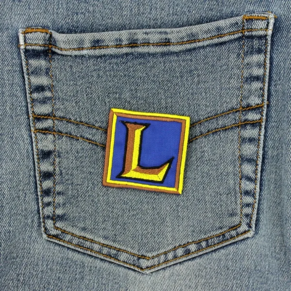 small LoL Old Icon Embroidered Patch League of Legends over white background on black jeans