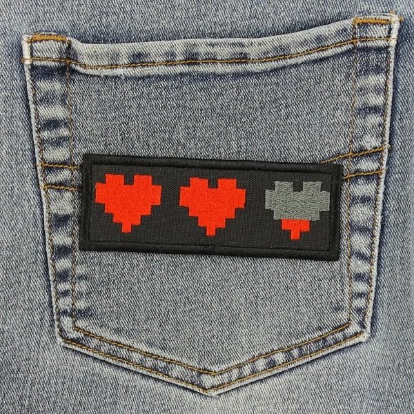 medium Pixel Hearts Embroidered Patch on black jeans