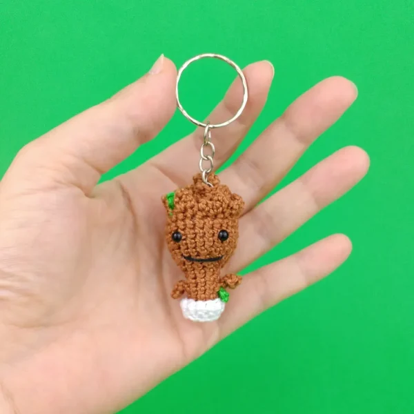 Groot Baby Plant Keychain on holding hand over green background