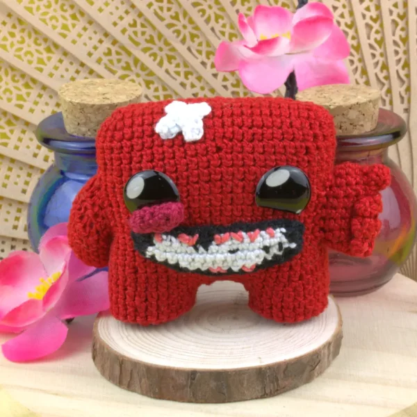 Super Meat Boy Crochet Amigurumi next to decorative flowers