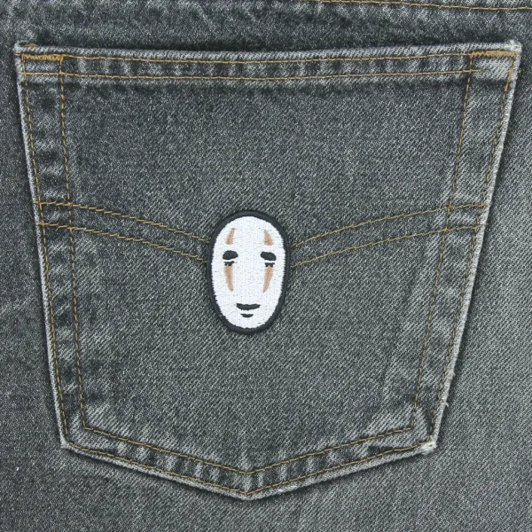 small Anime Fantasy Mask Embroidered Patch on black jeans