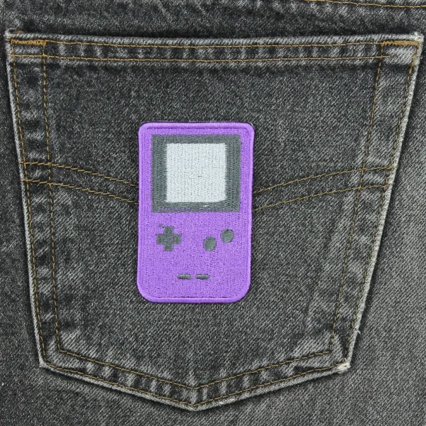 purple Handheld Game Boy Console Embroidered Patch on black jeans