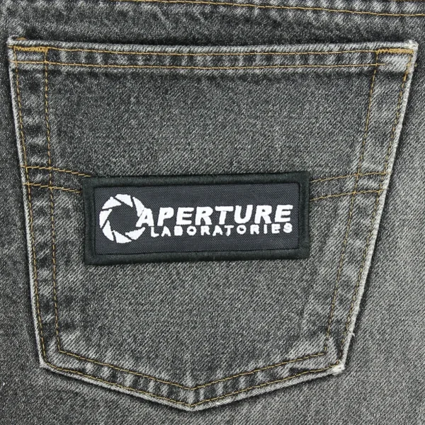 Portal Aperture Laboratories Embroidered Patch on black jeans