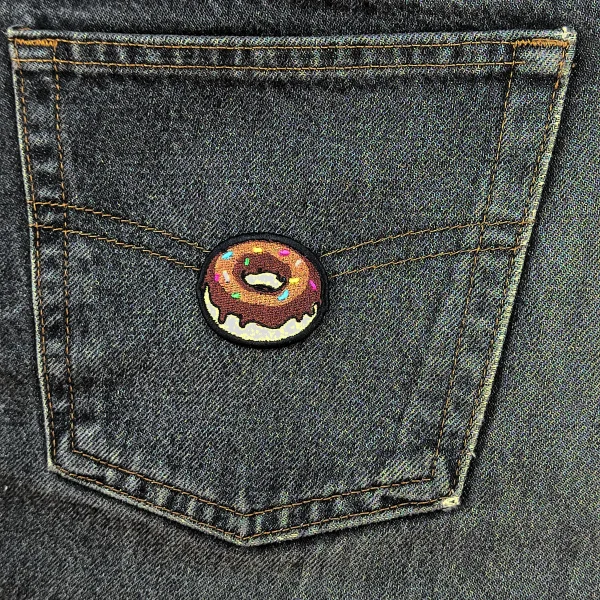 Small Chocolate Donut Embroidered Patch on black jeans