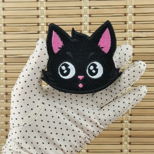 Kawaii black cat head embroidered patch size M in hand