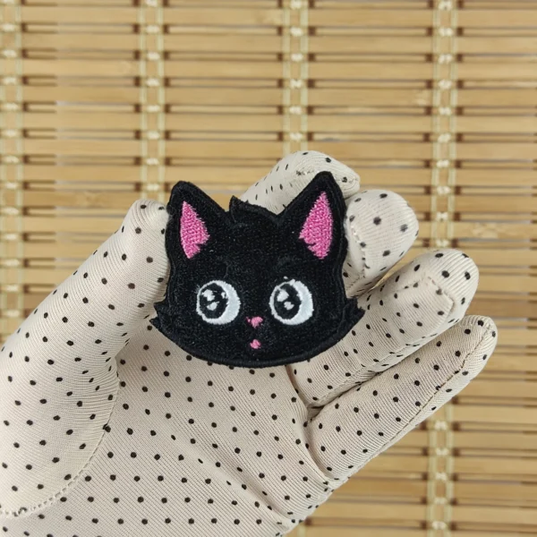 Kawaii black cat head embroidered patch size s in hand